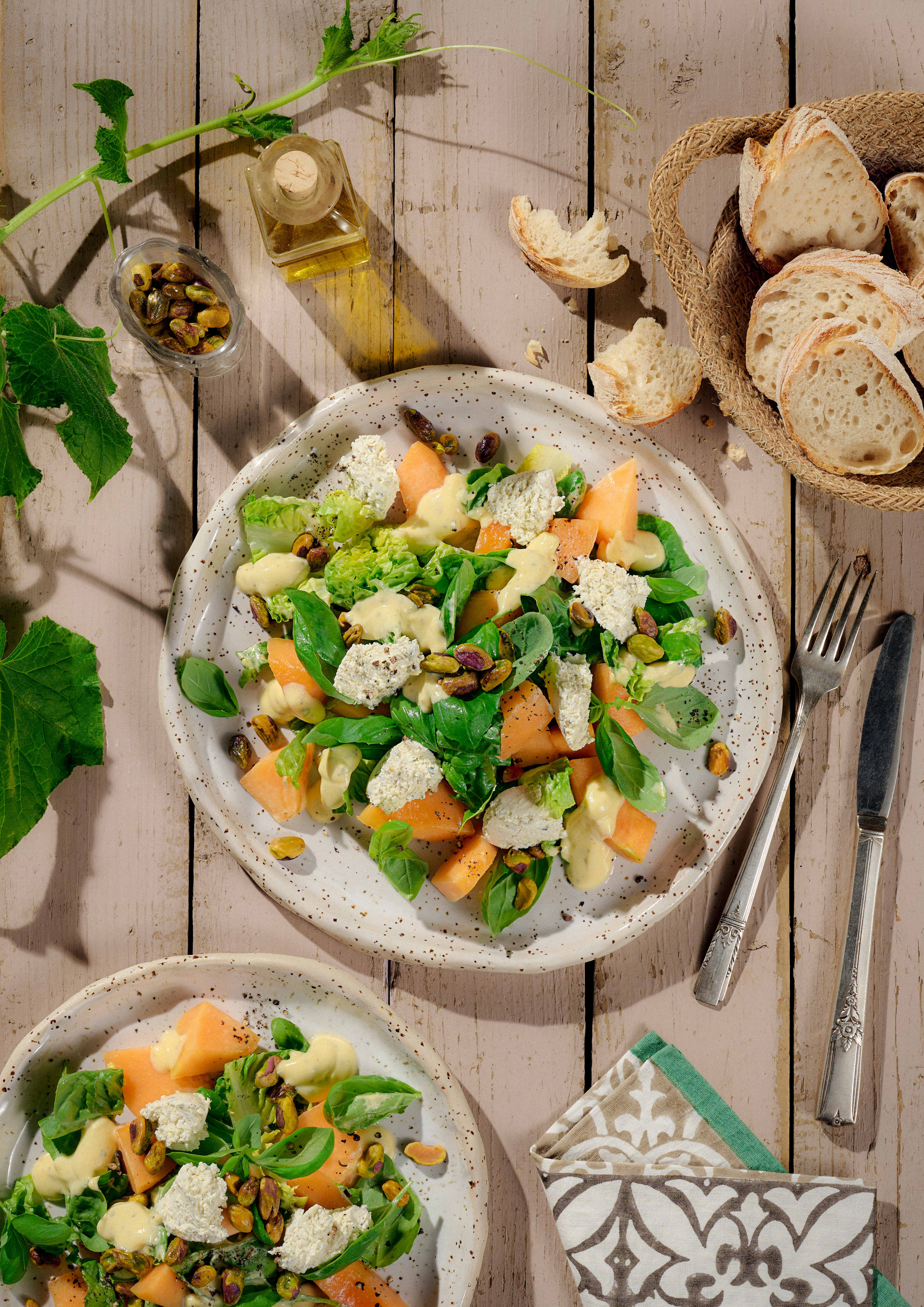 Wunderbarer Sommersalat auf einem runden Teller serviert mit Melone, Basilikum und BRESSO feine Kräuter