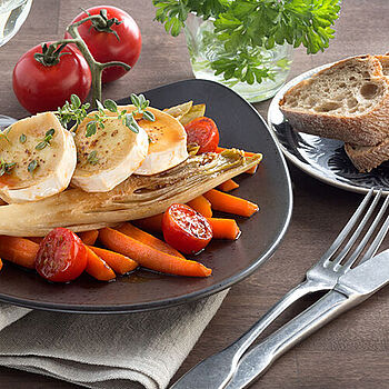 Eine appetitliche Bruschetta mit frischen Tomaten und schmelzendem Käse, garniert mit Basilikum auf einem rustikalen Holzbrett.