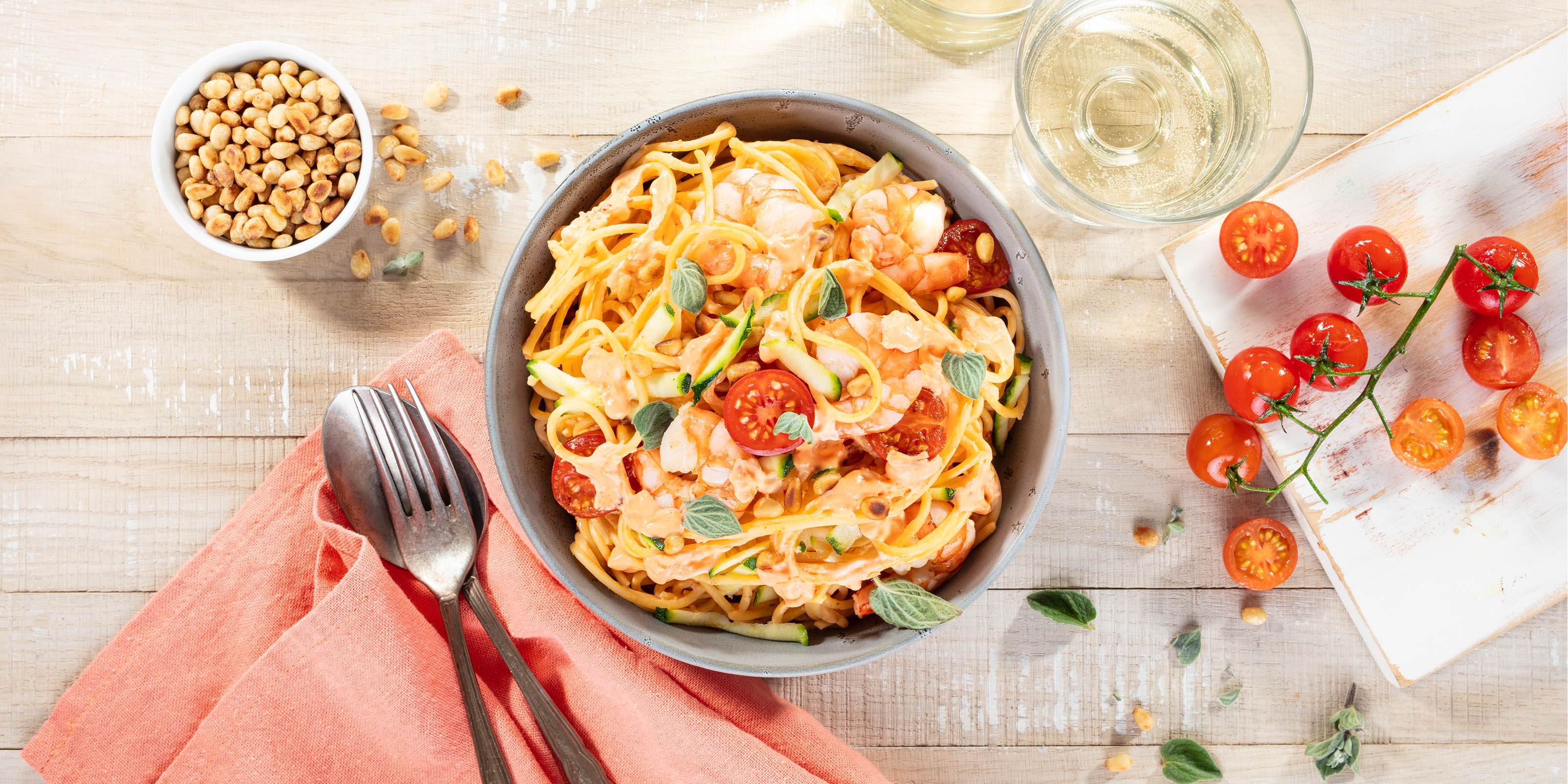 Pasta italienischer Art. Spaghetti mit Garnelen, frischen Zucchini, Cherrytomaten und Pinienkernen. 