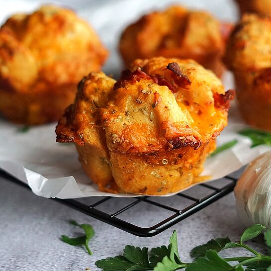 Saftige Pull-Apart Pizza Muffins mit Brötchenteig, Salami, Knoblauchbutter und Cheddar, goldbraun gebacken für den perfekten Party-Snack.