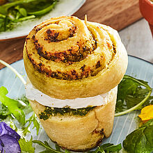 Frisch gebackene Bärlauch-Hefeschnecken neben einem Wildkräutersalat mit Camembert und Parmesan, ein ideales Frühlingsrezept.