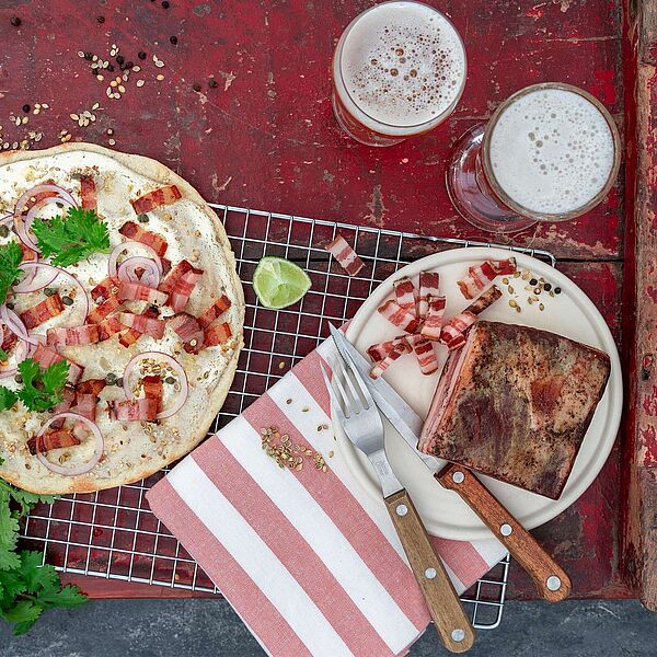 Eine köstliche Spezialität aus dünnem Teig, belegt mit Brunch, Speck und Zwiebeln: Unser Elsässer Flammkuchen