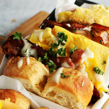 Koreanisches Egg Drop Sandwich mit getoastetem Brioche, fluffigem Rührei, Bacon, Feuerkäse und Sriracha-Mayonnaise