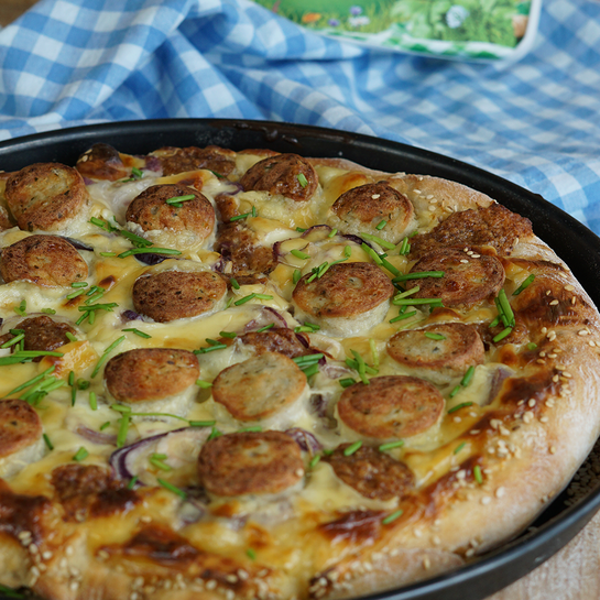 Außergewöhnliche Pizza nach bayerischer Art - mit Weißwurst und goldbraun gebackenem Käse