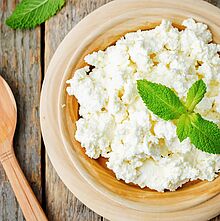 Krümeliger italienischer Ricotta Frischkäse in einer Holzschale angerichtet