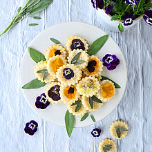 Herzhafte Blütenkekse mit Parmesan und Rosmarin, dekoriert mit essbaren Blüten