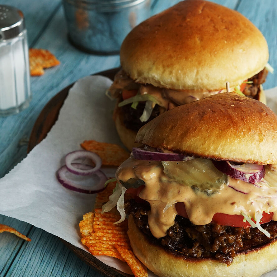 Saftiger Chopped Cheeseburger mit gehacktem Rindfleisch, geschmolzenem Cheddar und frischem Gemüse auf einem Brioche-Brötchen.