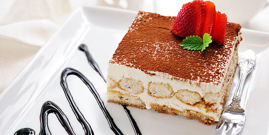 Klassisch italienisches Tiramisu mit Mascarpone und Schokopulver. Garniert mit frischen Erdbeeren.