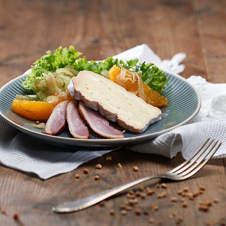 Passend zu Entenbrust: Knackiger Lollo Rosso Salat mit Fenchel und Orangen, einem Mandel-Honig-Topping und einer Scheibe Saint Albray Käse. 