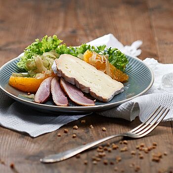 Passend zu Entenbrust: Knackiger Lollo Rosso Salat mit Fenchel und Orangen, einem Mandel-Honig-Topping und einer Scheibe Saint Albray Käse. 