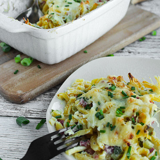 Ofen-Spätzle im Flammkuchen-Style mit Gouda, Schinkenwürfeln und Frühlingszwiebeln – einfaches, herzhaftes Ofengericht für die ganze Familie.