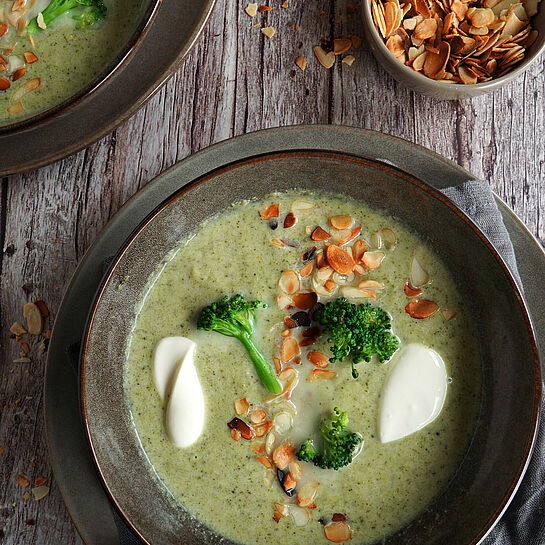 Würzige Brokkolisuppe mit Knoblauch und Zwiebeln, verfeinert mit Brunch Natur und knusprigen Mandeln als Garnitur.