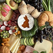 Farbenprächtiges Osterbrunch Board Rezept mit Käsevielfalt, Obst, Croissants und einen Schokohasen in der Mitte