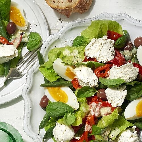 Frischer Salat mit gekochten Eiern, Oliven, Bohnen, Basilikum und Bresso Frischkäse