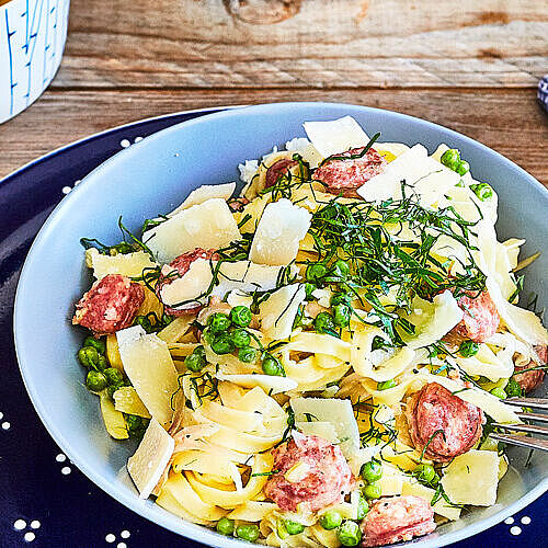 Tagliatelle mit Erbsen, Salsiccia und Grana Padano wird zur sommerlichen Gaumenfreude