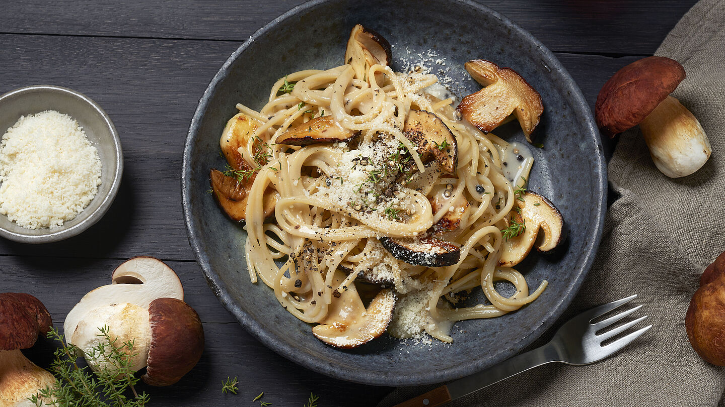 Cremige Pilzpasta mit angebratenen Steinpilzen, frischen Kräutern und Parmesan