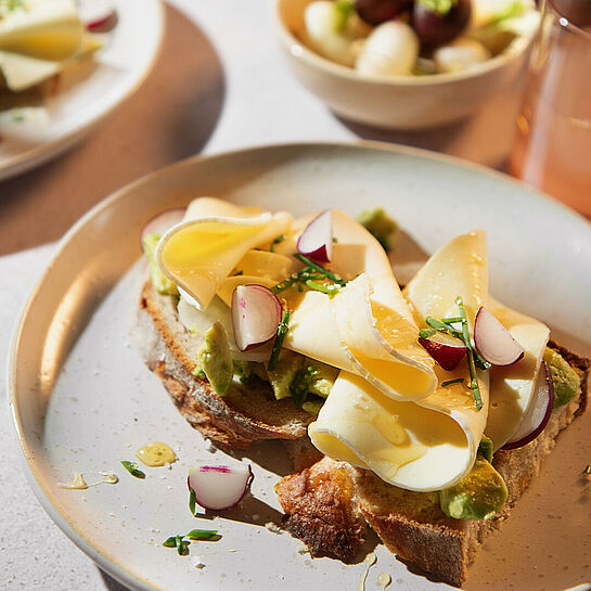 Zum Anbeißen! Frisches Bauernbrot mit Käse und Avocado. Verfeinert mit einem TL Honig. 