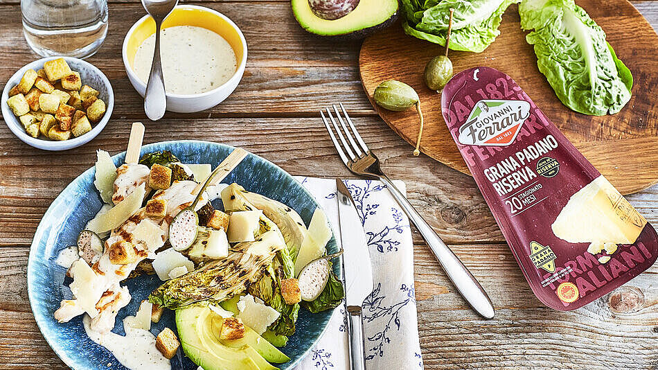 Grana Padano Parmesan als Topping für gegrillten Caesar Salat mit knusprigen Brot Croutons