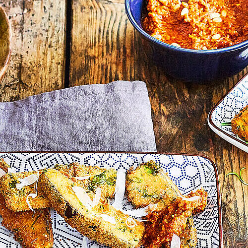 Rustikaler Tisch gedeckt mit frittierten Auberginen, Tomaten-Pesto und frischem Parmesan