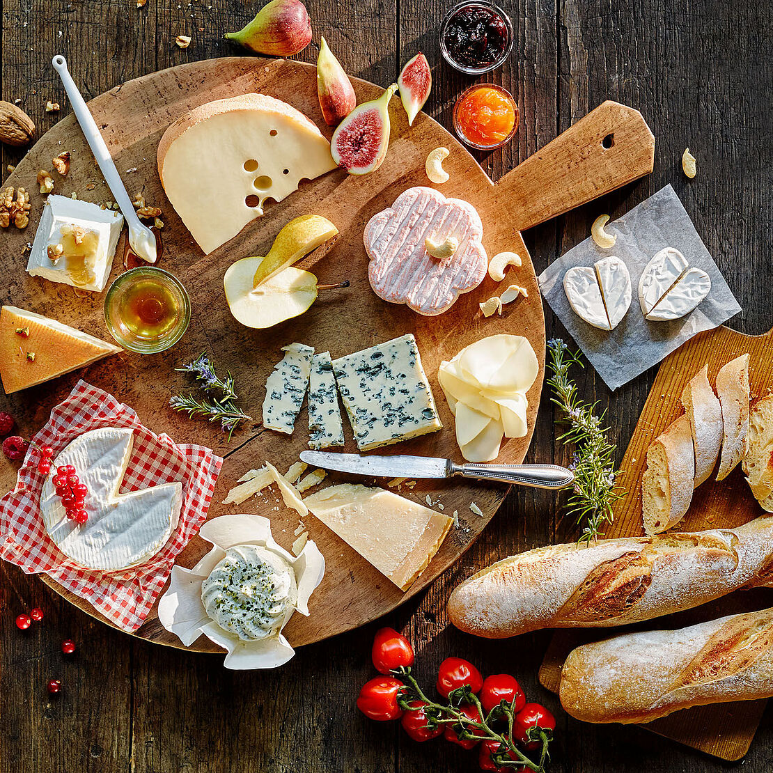 Premium Käsepicknick-platte mit zahlreichen Käsevariationen und frischem Baguette lässt Käseherzen höher schlagen