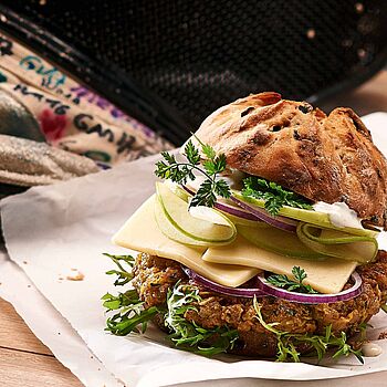 Zum Anbeißen! Vegetarischer Burger mit Butterkäse und frischem Gemüse. Abgerundet mit einem Honig-Minze Dressing. 