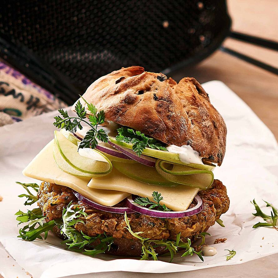 Zum Anbeißen! Vegetarischer Burger mit Butterkäse und frischem Gemüse. Abgerundet mit einem Honig-Minze Dressing. 