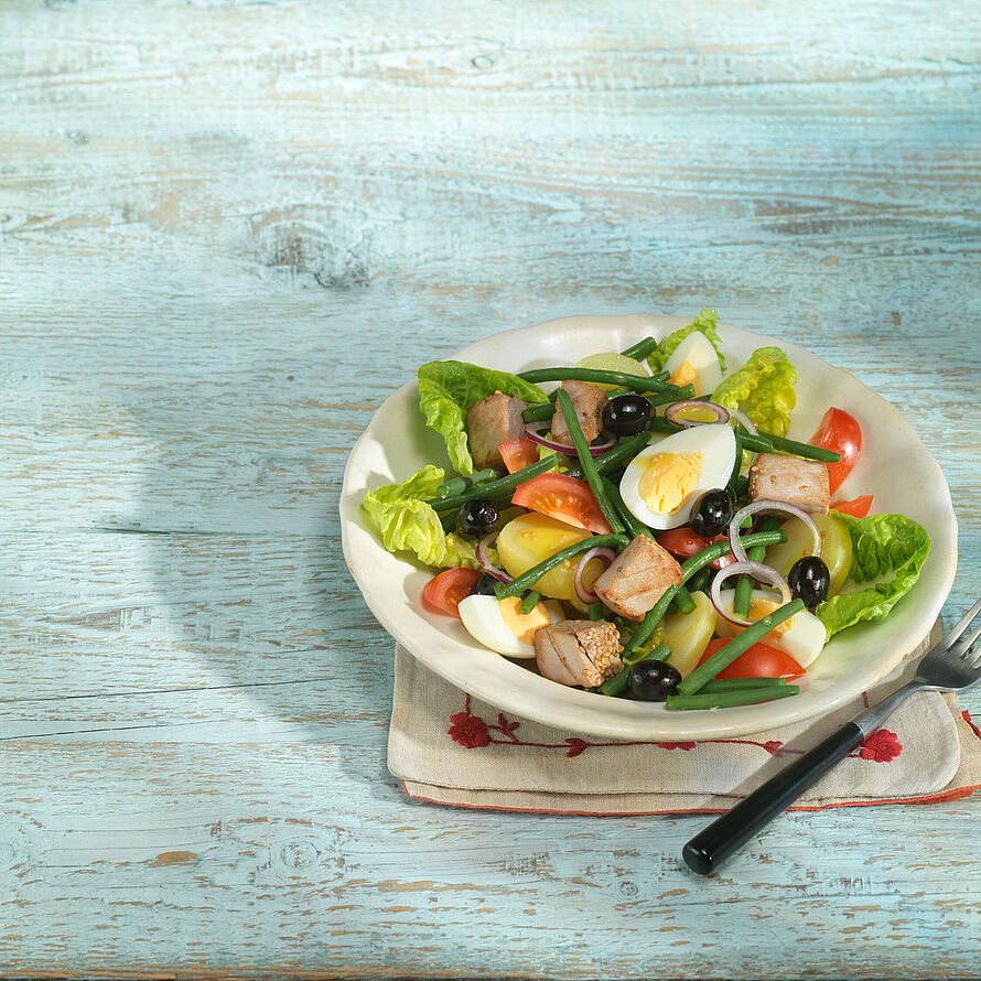Toll angerichteter Nizza Salat mit Thunfisch, Kartoffeln, Ei, Tomaten, Oliven, Anchovis und Pinzessbohnen
