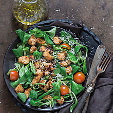 Feldsalat mit Kirschtomaten und Hähnchenbrustfilet mit fein geraspeltem Parmesan Käse. Italienisches Dressing mit Olivenöl und Balsamico. 