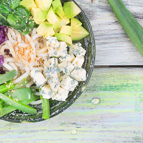 Rezept für eine Buddha-Bowl gefüllt mit Udon-Nudeln, Avocado, Saint Agur Blauschimmelkäse und vielem mehr.