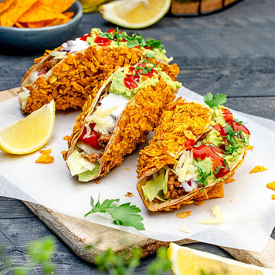 Der Taco Trend: Knusprige Crispy Tacos gefüllt mit würzigem Hackfleisch, frischen Tomaten, Eisbergsalat und cremiger Avocado-Sauce.