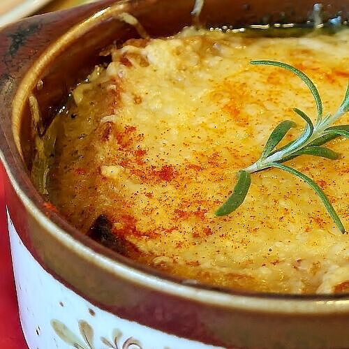 Zwiebelsuppe mit Esquirrou-Käse: Eine Schüssel mit einer reichhaltigen Brühe, die mit herzhaftem Rindfleisch gefüllt ist.