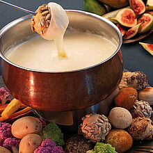 Käsefondue mit Saint Albray mit kreativen Zutaten wie Brot-Pops, Brotchips, Birnen, Feigen, Blumenkohl und Karotten. 