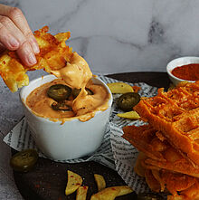 Knusprige Pommes-Waffeln im Waffeleisen gebacken, serviert mit cremiger, leicht scharfer Chilli Cheese Sauce aus Premium Cheddar.