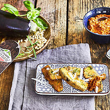 Rustikaler Tisch gedeckt mit frittierten Auberginen, Tomaten-Pesto und frischem Parmesan