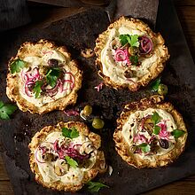 Kleine Pizzen mit Blumenkohl und einem cremigen Belag aus Brunch, marinierten Zwiebeln, frischen Champignons und Oliven, verfeinert mit Petersilie.