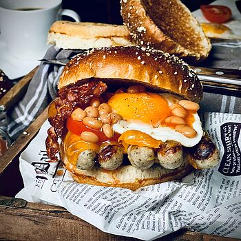 Was ein Anblick, Breakfast Burger mit Bratwürstchen, Spiegelei, Bohnen und Speck. Einfach lecker! 