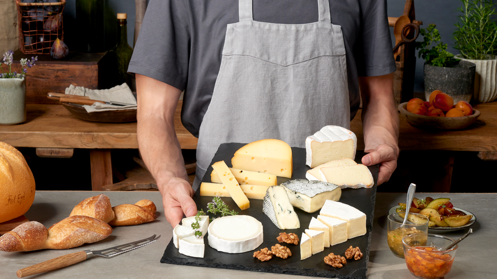 Käsetester Header Käsesommelier Käsesommelier mit einer Käseplatte.