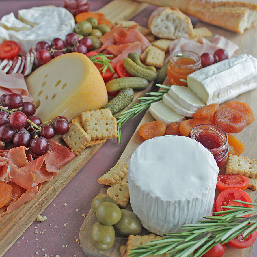 Eine köstliche französische Charcuterie-Platte mit verschiedenen Käsesorten, frischen Früchten und herzhaften Beilagen, perfekt für gesellige Abende.