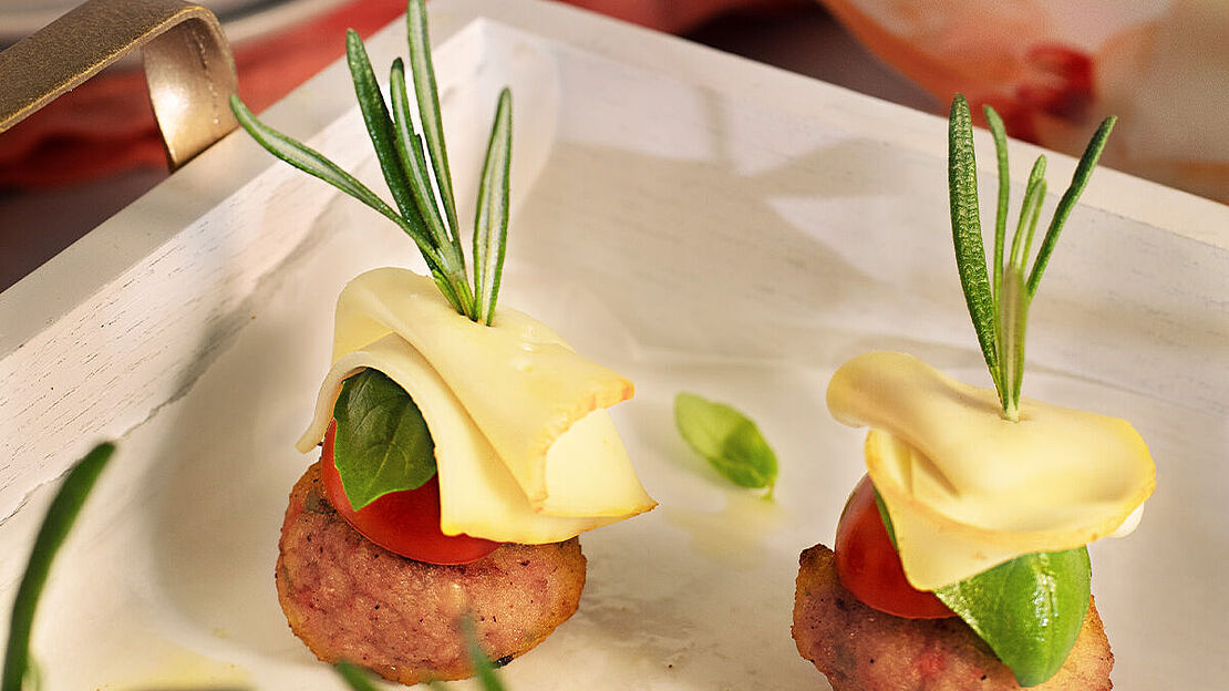 Rosmarin Spieße mit Géramont auf einem weißen Tablet als Fingerfood serviert