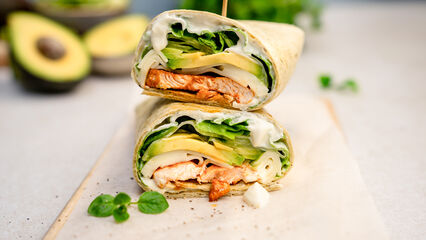 Hähnchen-Avocado-Wrap, gefüllt mit saftigem Hähnchen, frischer Avocado, knackigem Salat und Gurke, eingewickelt in einem Tortilla.