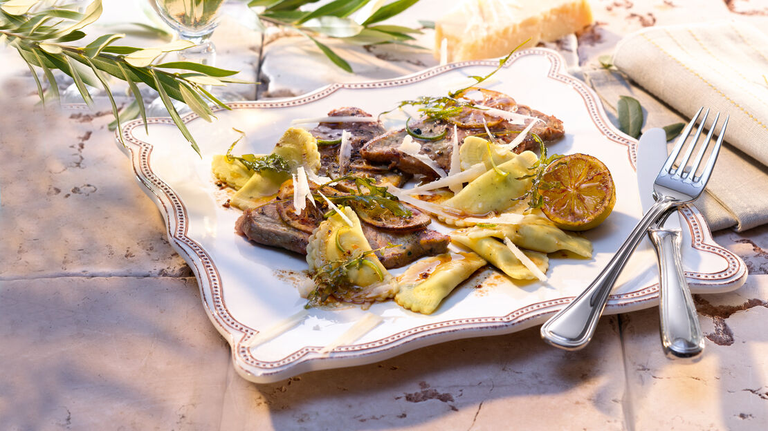 Käasewissen: Ricotta mit Kalbsschnitzel und Rucola Salat Kalbsschnitzel in Zitronensauce auf einem viereckigen Teller mit Parmesan überstreut
