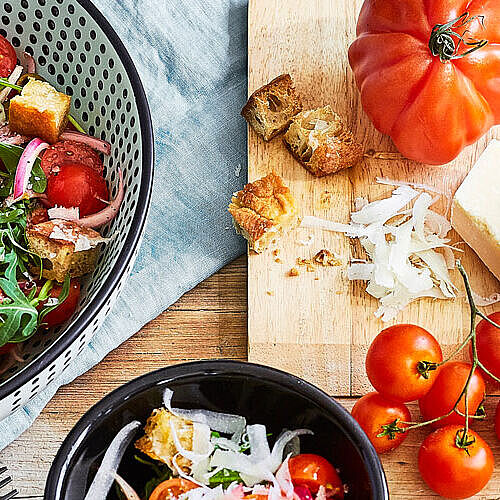 Knackiger Brotsalat mir frischen Tomaten, Ruccola Salat, Zwiebeln und verfeinert mit Parmesan Käse.