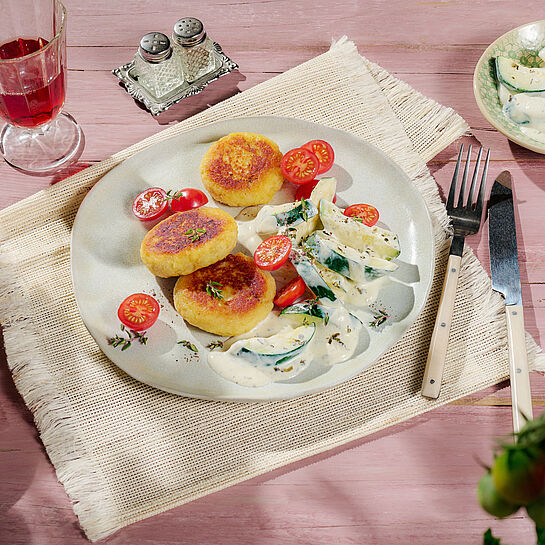 Knusprige Kartoffelpatties mit zarten Zucchini-Stücken und halbierten Cocktailtomaten - abgerundet mit einer BRESSO Feine Kräuter Sauce