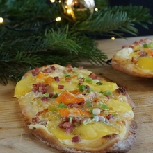 Dinnete mit Kartoffeln, Speck und Saint Albray dekorativ serviert mit einem Tannenbaum Besteck auf einem Holztisch