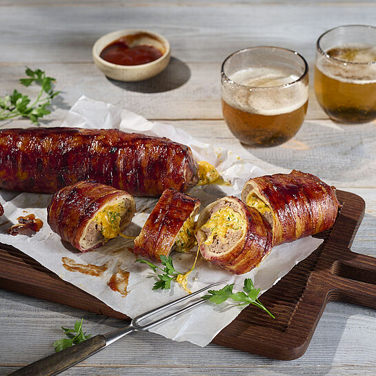 Hackfleisch-Bacon-Käse-Rolle mit Cheddar, Jalapeños und BBQ-Glasur, umwickelt in knusprigem Bacon.