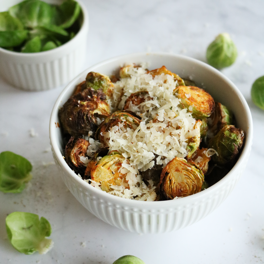 Gerösteter Rosenkohl mit Parmesan – einfaches Rezept Gerösteter Rosenkohl mit frisch geriebenem Parmesan in einer weißen Schüssel.