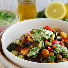 Knuspriger Gnocchi-Salat mit goldbraun gebratenen Kichererbsen, geröstetem Gemüse und cremigem Kräuter-Dip in einer weißen Schüssel.​