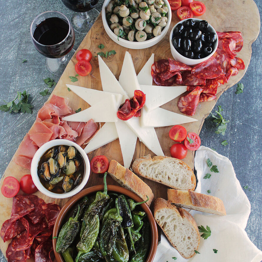 Das spanische Tapas-Board bietet eine bunte Mischung aus Ziegenkäse, Chorizo, Serranoschinken, Oliven, Miesmuscheln und Pimientos de Padrón.