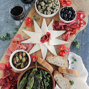 Das spanische Tapas-Board bietet eine bunte Mischung aus Ziegenkäse, Chorizo, Serranoschinken, Oliven, Miesmuscheln und Pimientos de Padrón.