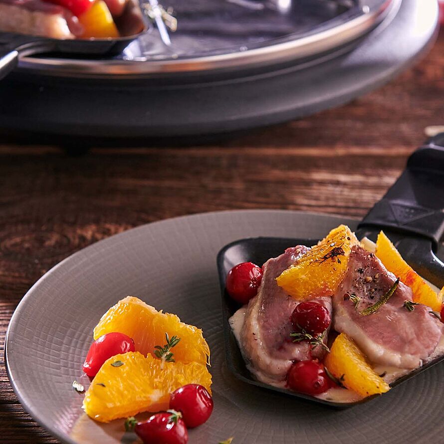Exquisites Raclette-Erlebnis mit zartem Entenfilet, begleitet von der frischen Note von Orange